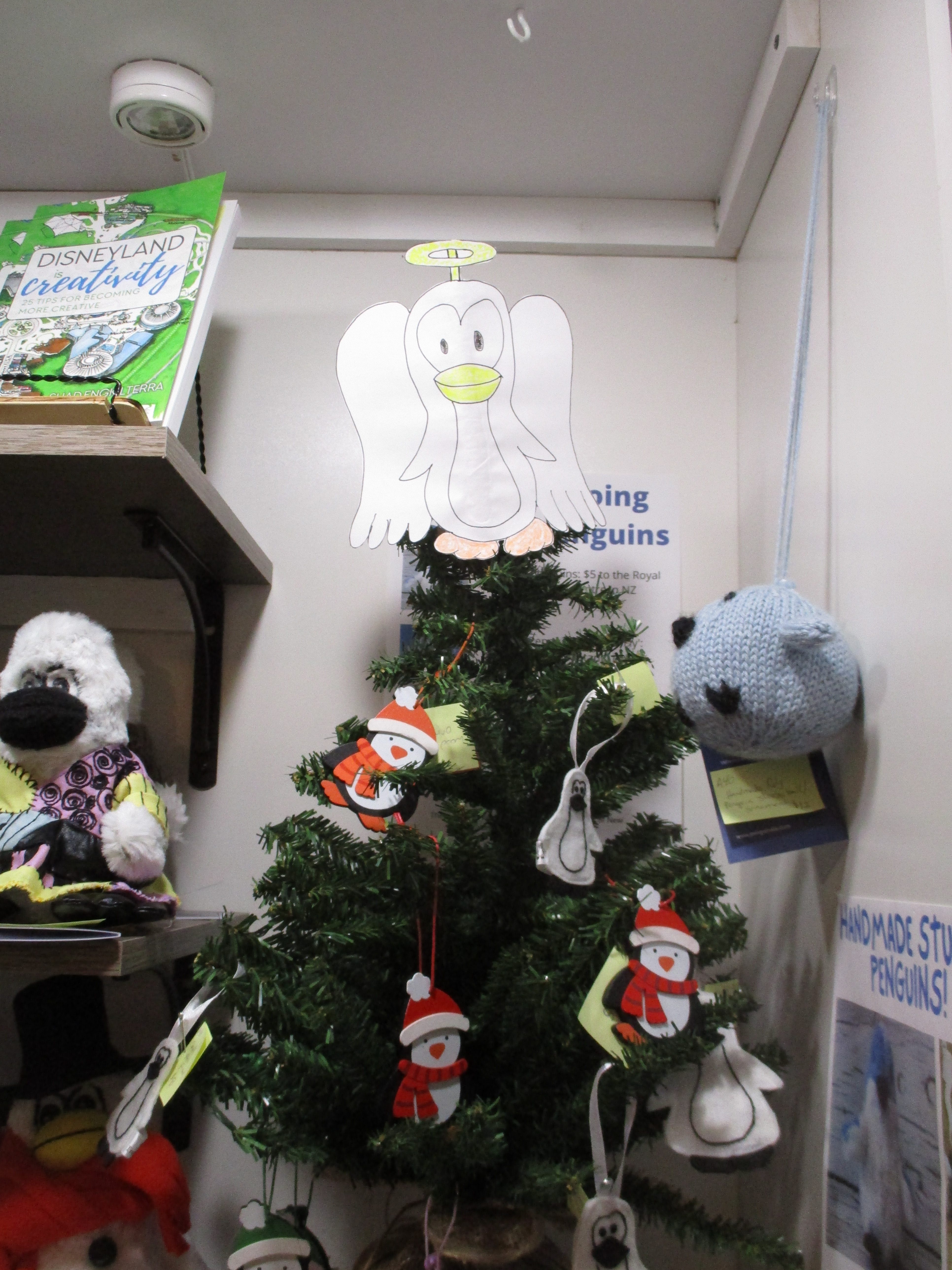 Penguin angel tree topper on top of a tree.