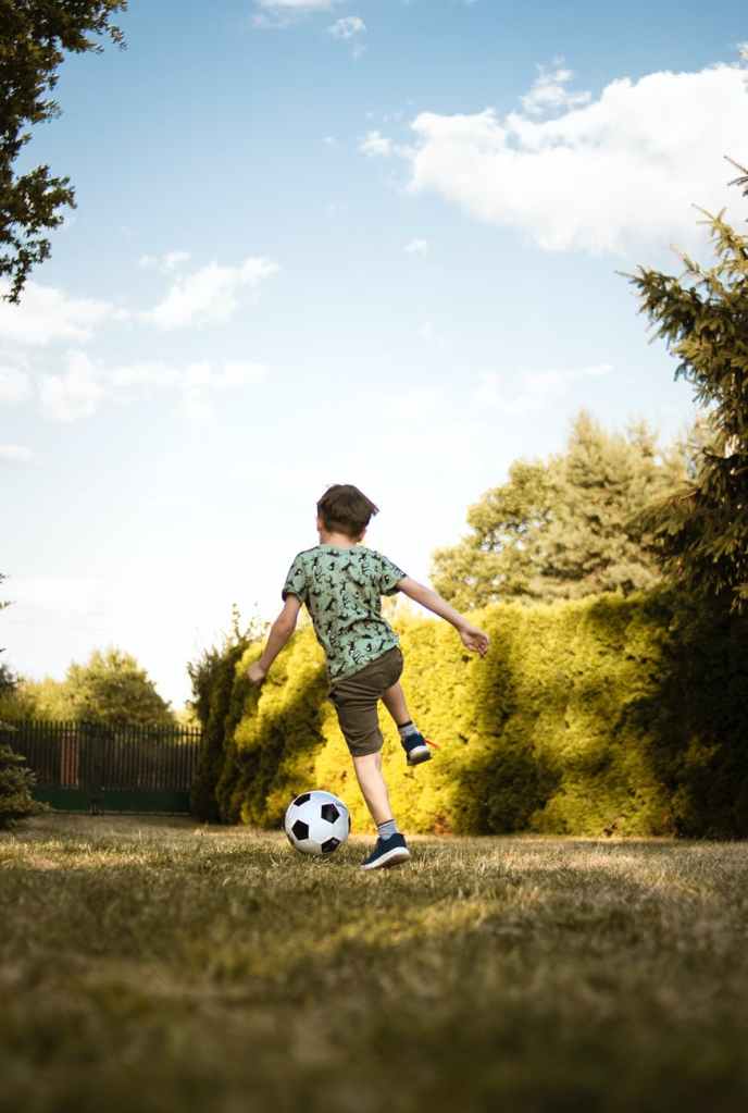 Boy playing soccer by himself