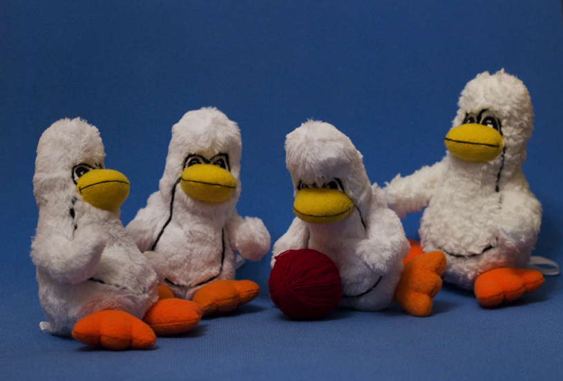 Stuffed animals (penguins) play with a ball of yarn